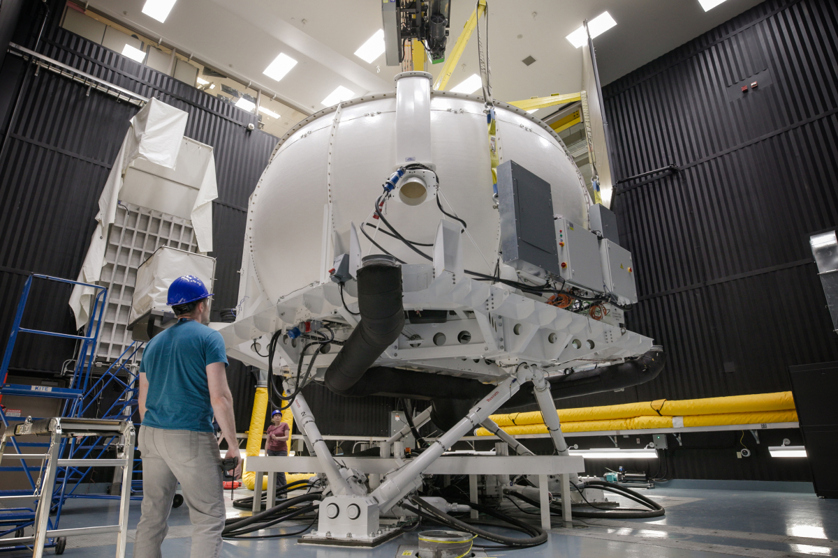 A photo of workers positioning DriverLab on the hexapod motion base in CEAL.